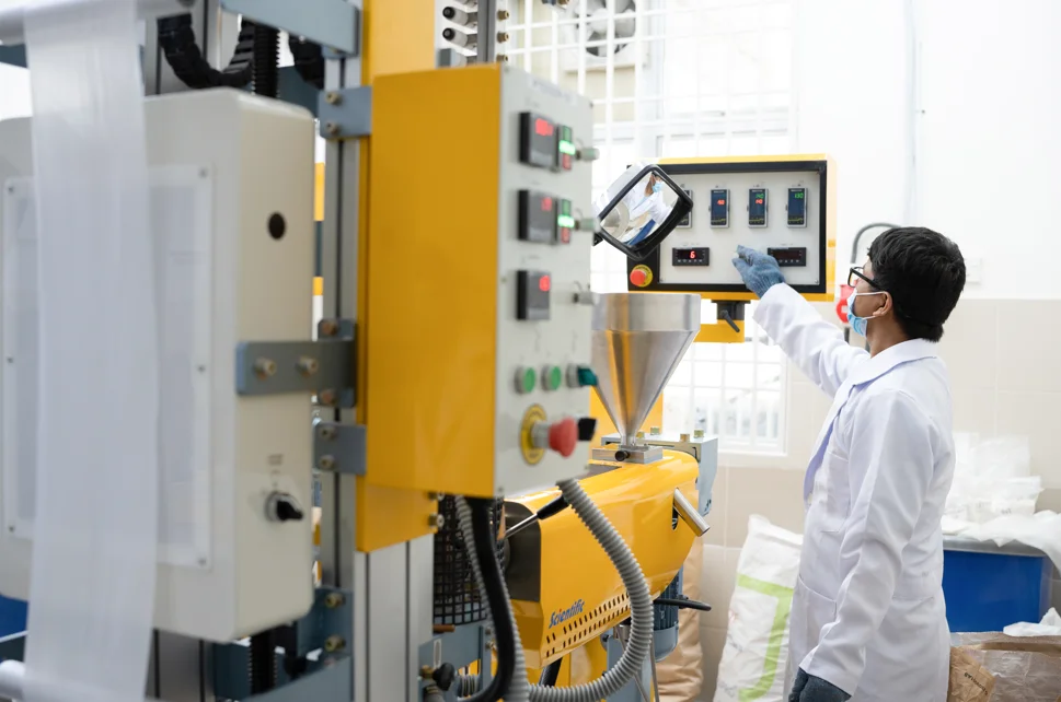 Technician operating compounding equipment in the R&D lab